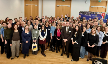 A group of people standing together in front of a banner showing the EASNIE logo